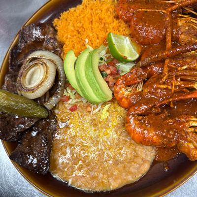Grilled  steak and shrimp in red sauce, served with rice, beans, avocado, and pico.
