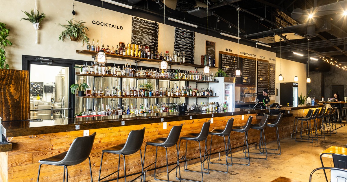 Interior, marble counter bar with wooden front, comfy bar stools, large drink shelf behind the bar