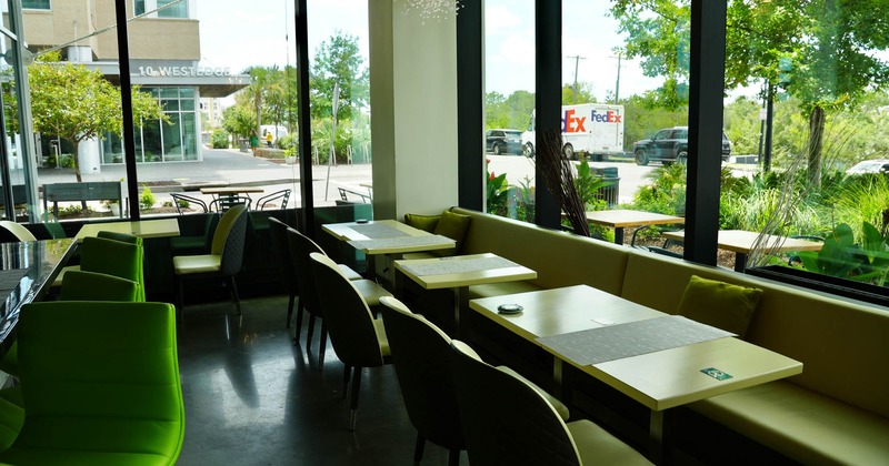 Interior of a modern cafe with booth seating, tables, and large windows