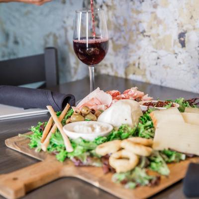 Antipasto board and a glass of red wine.