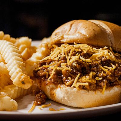 Sloppy Joe, topped with cheddar, with a side of fries