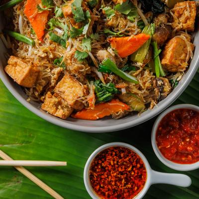 Crystal noodle bowl with spices on side, top view