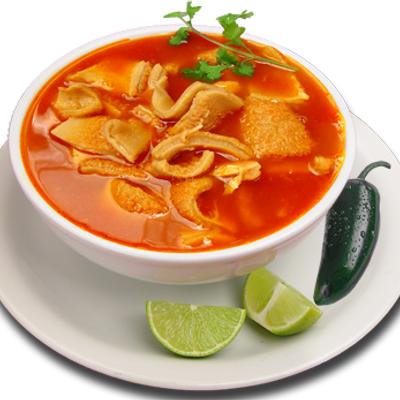 Spicy tortilla soup served with lime wedges.