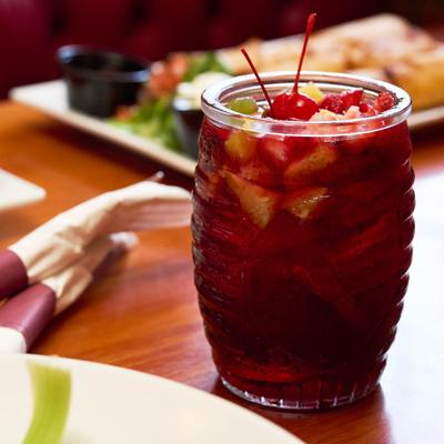 Red fruit drink topped with cherries and citrus.
