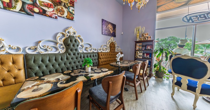 Cozy seating area with vintage-style booth seats along the wall and tables with decorative tabletops