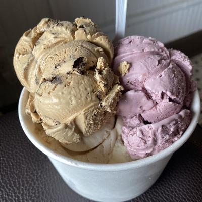 A cup of ice cream with two flavors, coffee and pink berry.