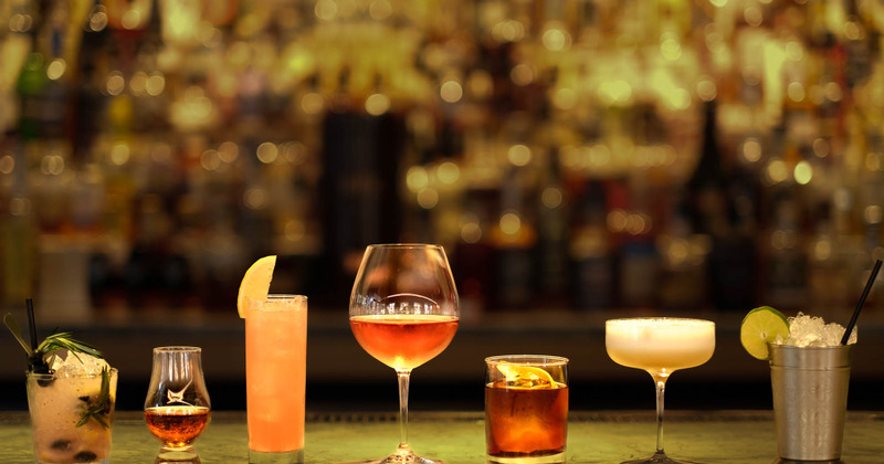 Glasses of cocktails displayed outside, on grass