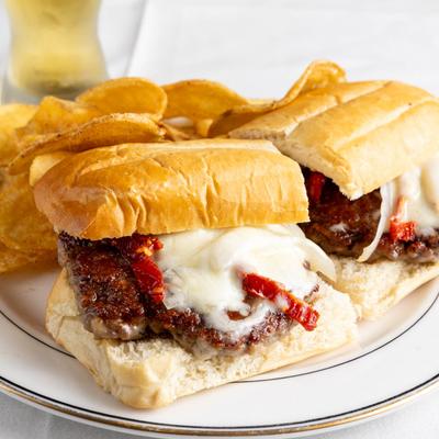 Italian sausage sandwich, served with potato chips, front view.