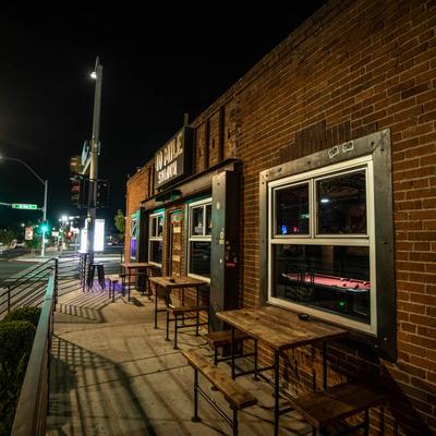 Tables and chairs outside of the venue, on the sidewalk.