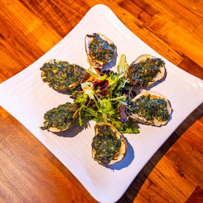 Pier 16 Rockefeller oysters, served on a plate, top view.