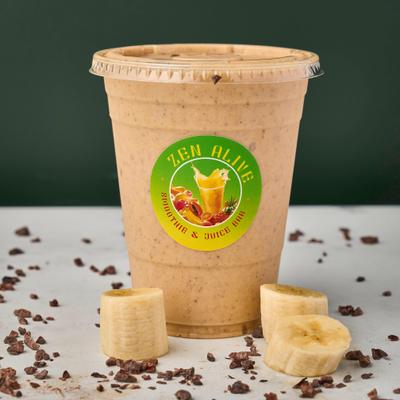 You're Amazing Smoothie served with sliced bananas and scattered cocoa nibs.