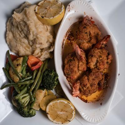 Seafood Stuffed Shrimp served with mashed potatoes, sauteed vegetables and lemon.