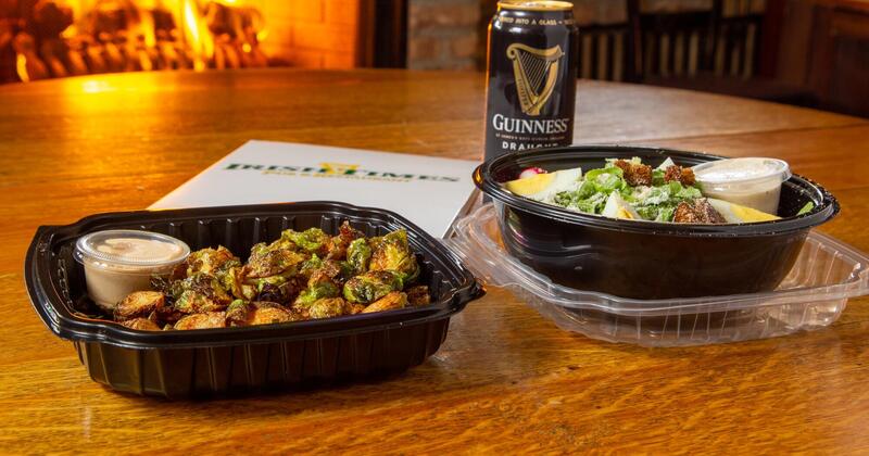 Two dishes served in to-go containers and a can of Guinness