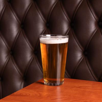 Glass of beer served on the table.