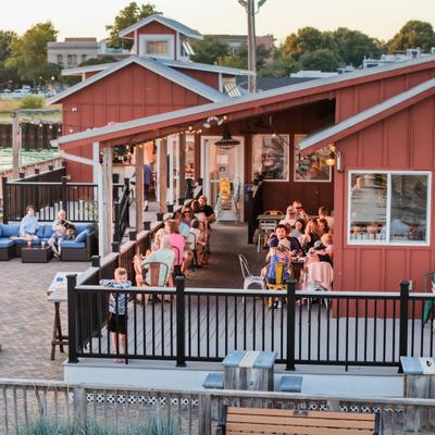Restaurant wooden building with a red exterior and a fenced outdoor deck for patrons.