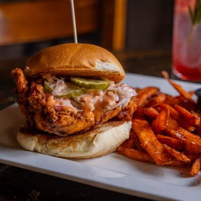 Crispy chicken sandwich served with sweet potato fries.