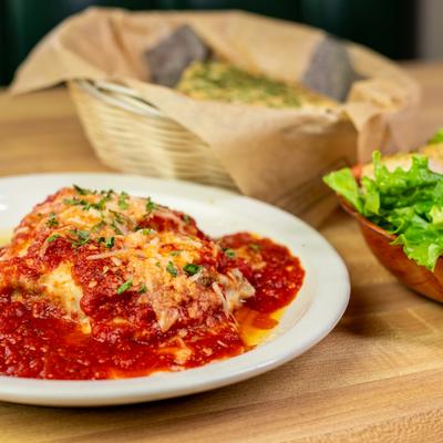 Lasagna topped with marinara, salad, and garlic bread.