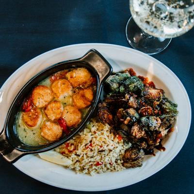 Baked scallops served with rice, Brussels sprouts, and sparkling wine.