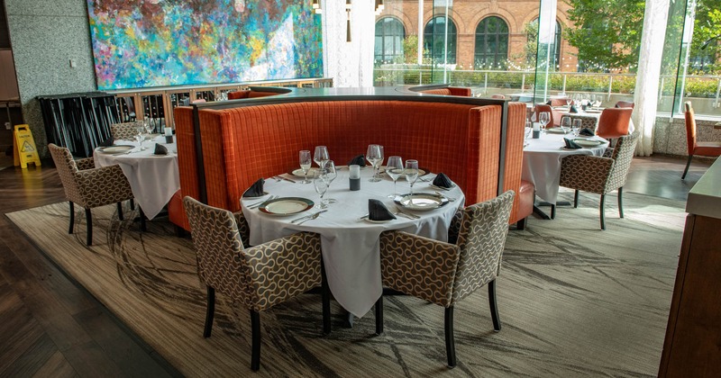 Interior, set table for four, chair and orange cushion seating