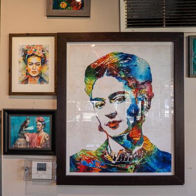 Wall decorated with multiple portraits of the Mexican artist Frida Kahlo.