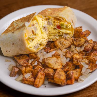 Breakfast burrito served with fried potatoes and onions.