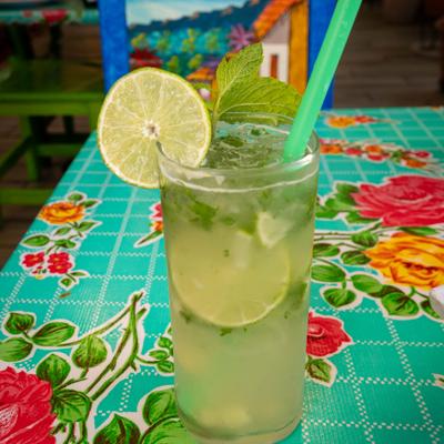 Mojito in a highball glass, garnished with mint and a lime wheel.