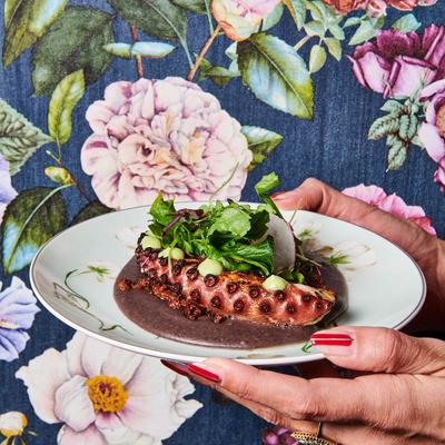 Hands holding a Grilled Octo plate.