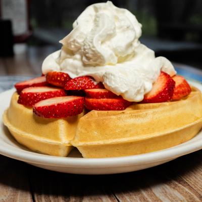Waffle with strawberries and whipped cream.