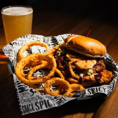 Fried pork tenderloin sandwich, with slaw, cheese, pulled pork, crispy onions, and onion rings.