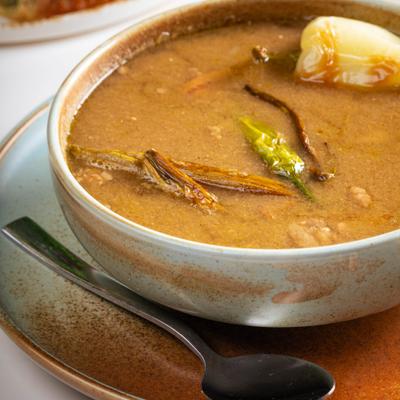 Mexican soup featuring diced steak, crispy bacon, and whole pinto bean.