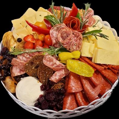 A charcuterie platter with cheese, salami, pepperoni, cherry tomatoes, crackers, and olives.