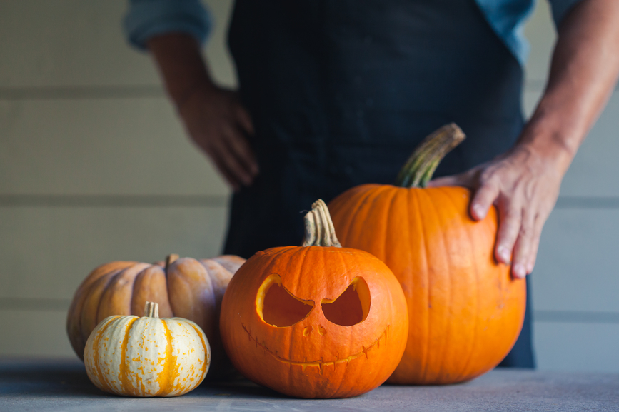 chef standing behind jack o lanterns