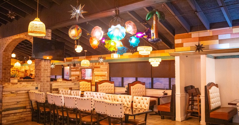 Interior, dining area, long table for sixteen people. seating booths in the back