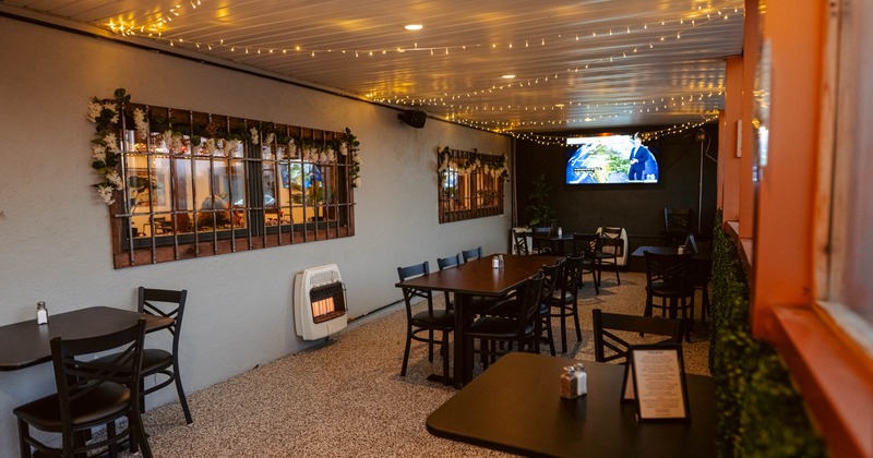 Interior, dining area, tables for two, four and six, carpet flooring, TV on the wall