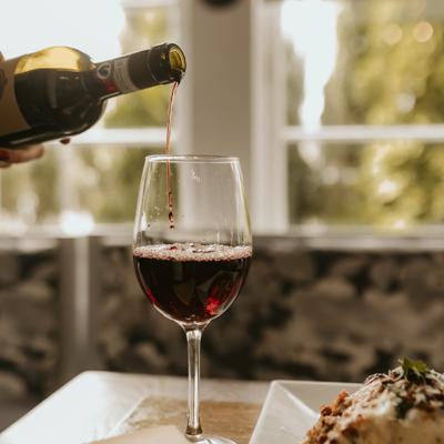 Red wine being poured from the bottle into a glass.