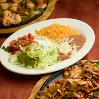 A Mexican dish with rice, beans, and fresh salsa, served with fajitas.