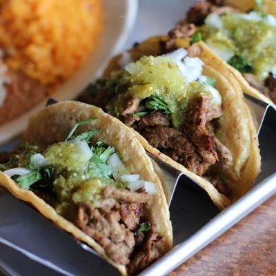 Bistec Tacos with cilantro, habanero, red onions and roasted tomatillo sauce.