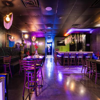 Interior with a seating area and a bar counter with stools and decorations.