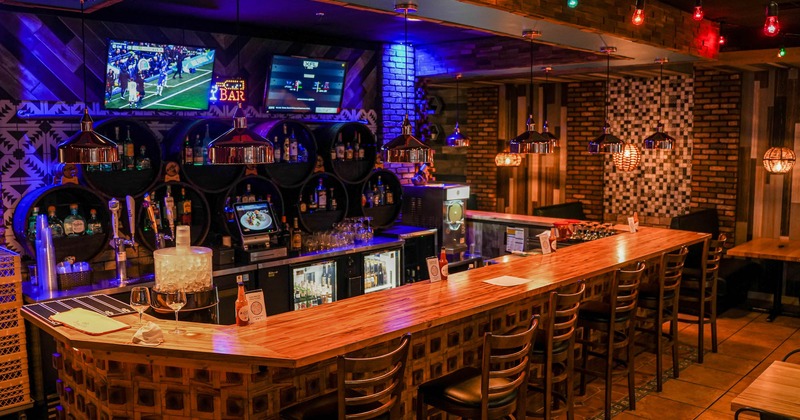 Bar with bar stools and TV's on the wall