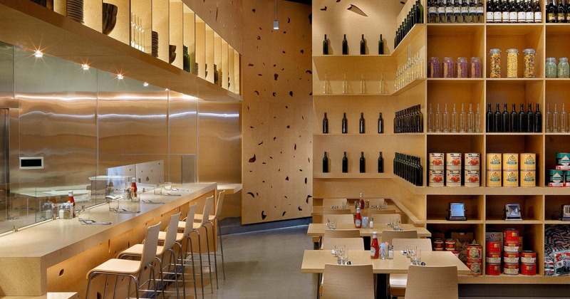 Interior, dining area, high table for five, tables for four, large wine and goods shelves