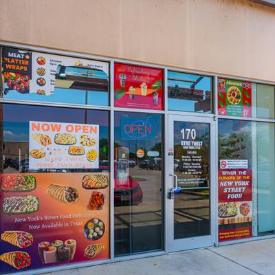 Storefront featuring a prominent window signage displaying menu offerings.