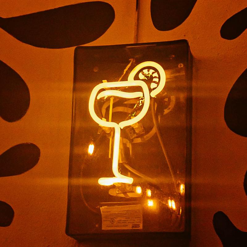 Neon sign in a cocktail glass shape with a lime wheel garnish.
