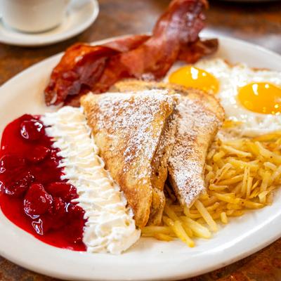 French Toast with two eggs, bacon , hash browns , strawberry sauce, whipped cream.