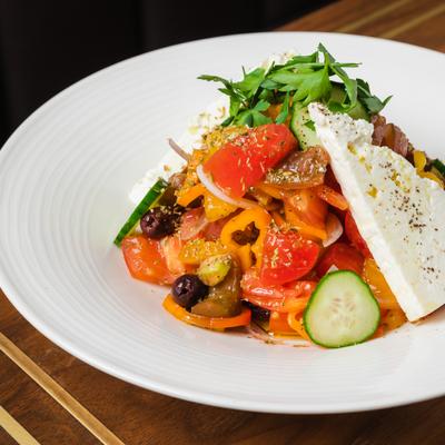Greek salad, with heirloom tomatoes, cucumber, sweet baby peppers, onions, olives, and feta