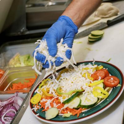 A hand preparing a meal.