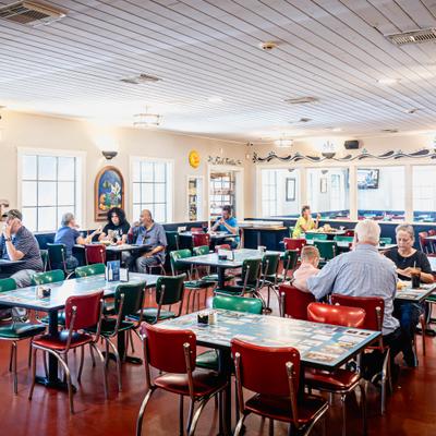 Restaurant's interior with people siting at the tables.