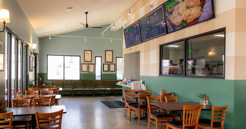 Interior seating area with tables, menu screens and framed awards