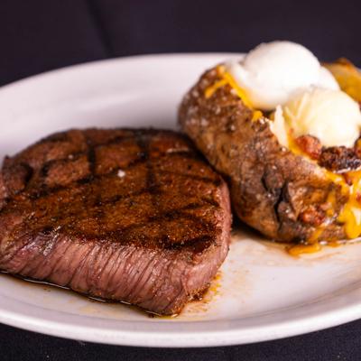 Grilled sirloin steak with a loaded baked potato.