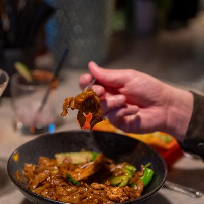 A guest eating a Thai dish.