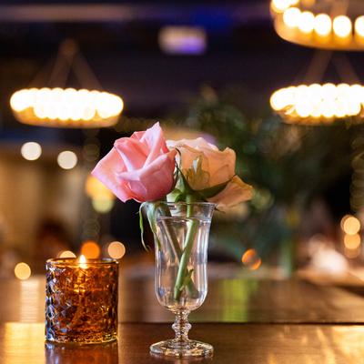 Floral arrangement and a candle on a table inside.